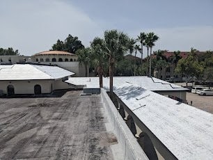 Roofer inspecting shingle roof to decide between repair and replacement