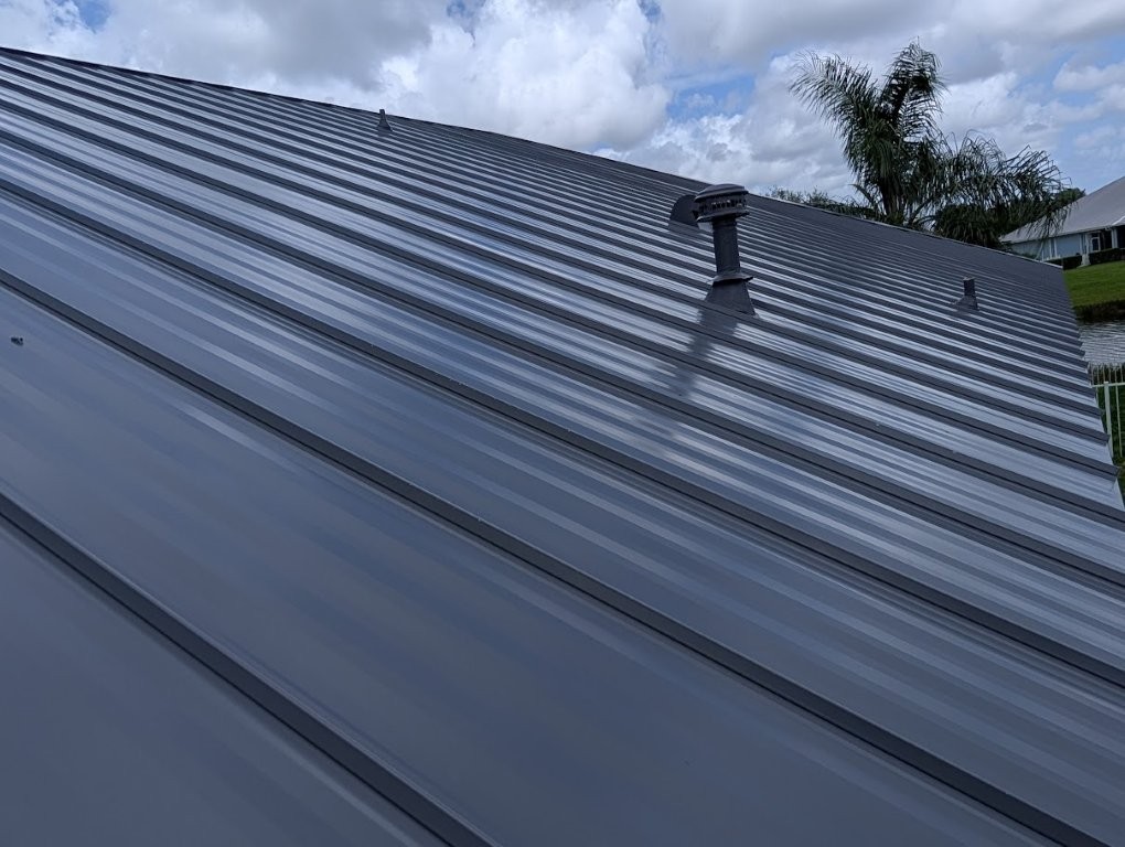 Standing seam metal panels being set on a Florida roof